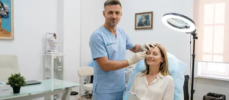 Plastic surgeon assessing upper and lower eyelids before blepharoplasty at Medical Time hospital in Belgrade